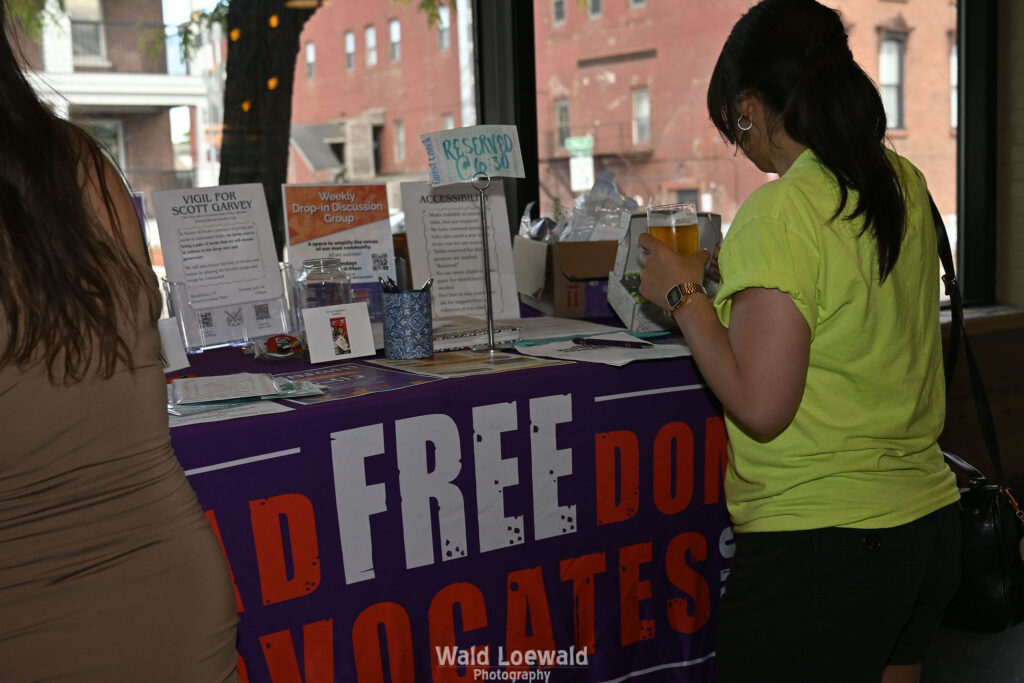 Two people looking at materials on the MadFreedom Advocates table