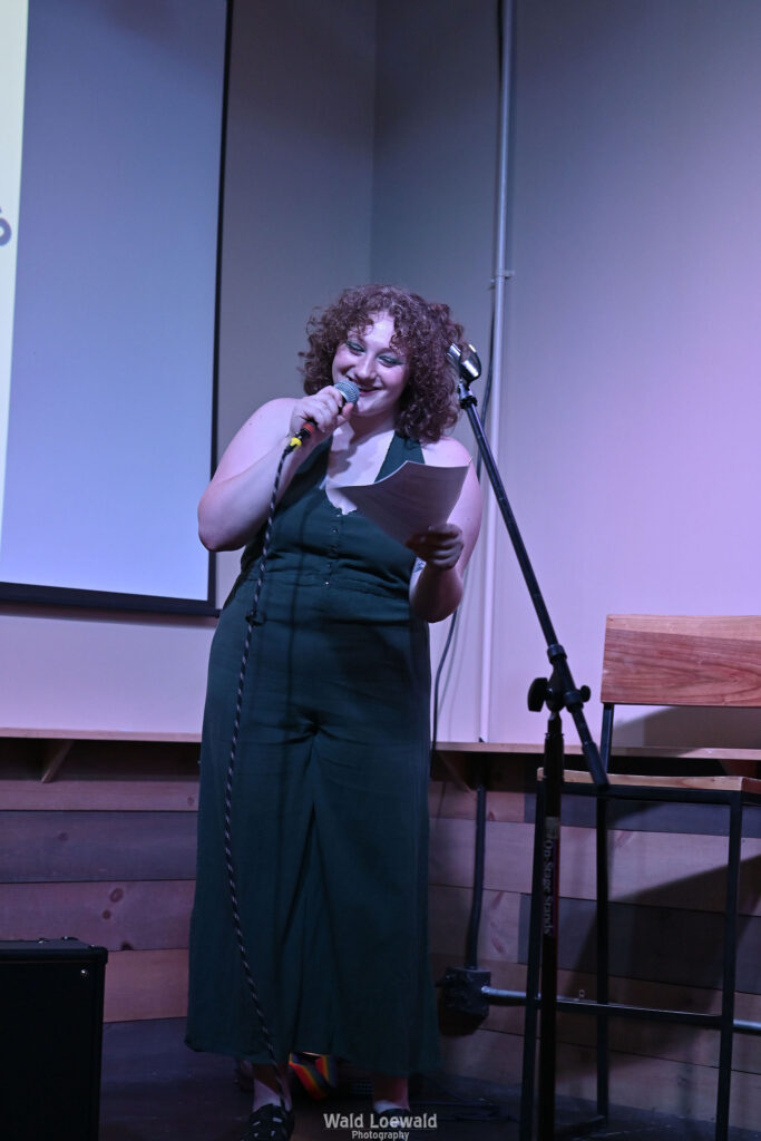 Performer behind a mic, smiling