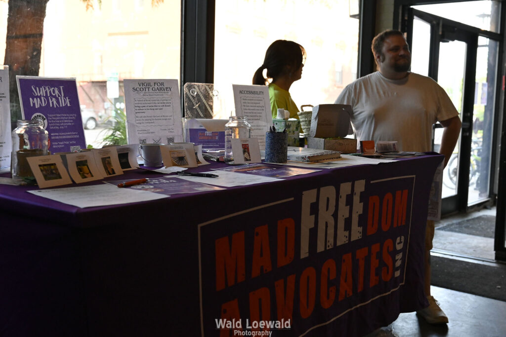 MadFreedom Advocates table with volunteers standing by