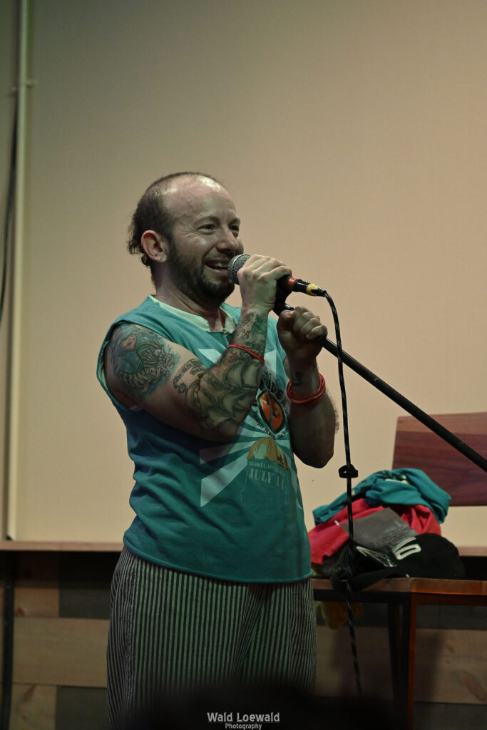 Calvin Moen in old Mad pride shirt in front of mic