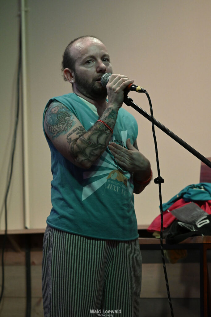 Calvin Moen in old Mad pride shirt in front of mic