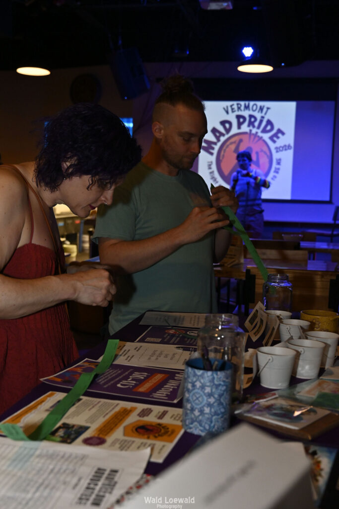 People surrounding MadFreedom Advocates table looking at materials