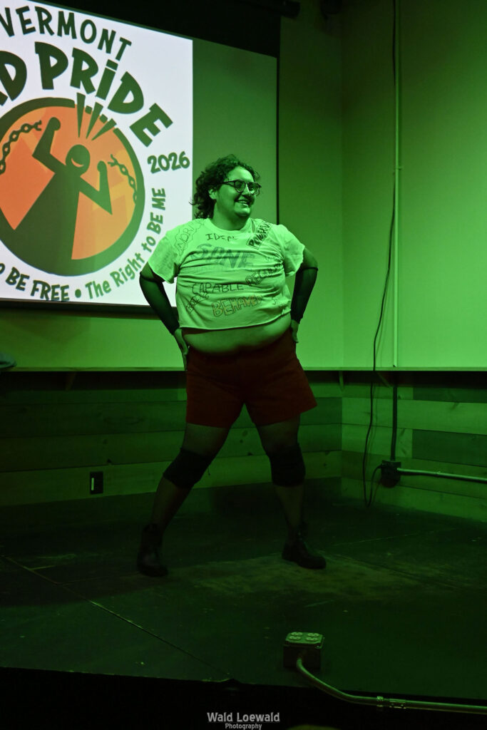 Performer in Mad Pride shirts performing in green lighting